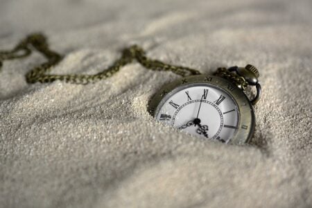 Watch-In-Sand-350-233 → Which God Saves? A packet watch, nearly buried in sand.